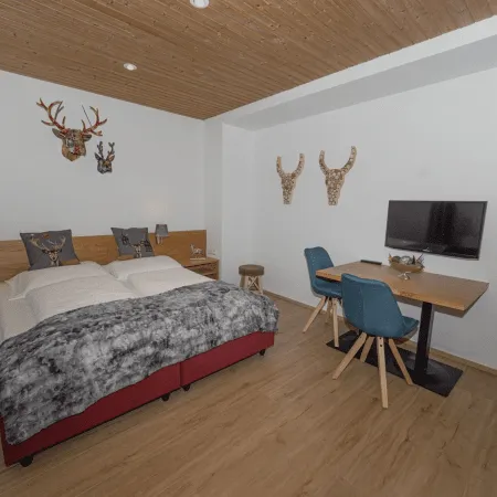 Helles Schlafzimmer mit Doppelbett, Tisch, Stühlen und Wanddekoration