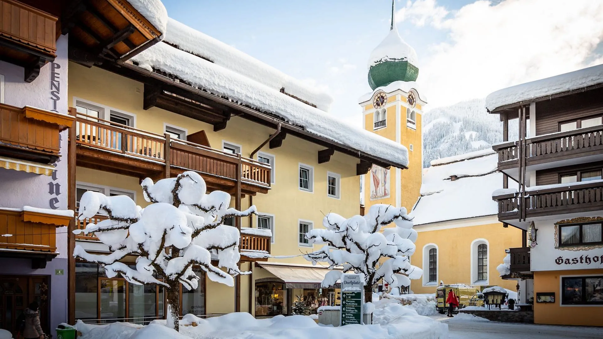 Schneebedeckte Stadtstraße mit traditionellen Gebäuden und Uhrturm